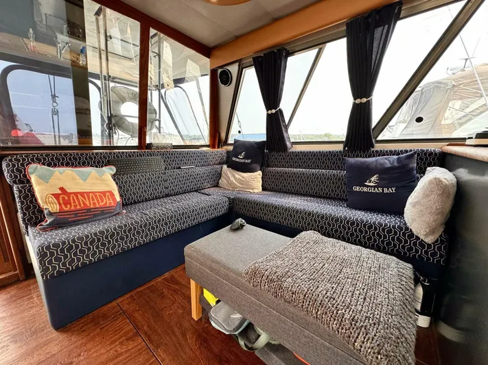  Yacht Photos Pics Interior of 1988 Bayliner 4550 Pilothouse with cozy seating and nautical-themed decor.