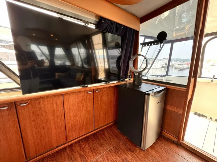  Yacht Photos Pics Interior of 1988 Bayliner 4550 Pilothouse with TV, mini fridge, and wood cabinetry.