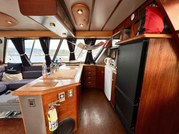  Yacht Photos Pics 1988 Bayliner 4550 Pilothouse interior with wood finish, kitchen area, and large windows.