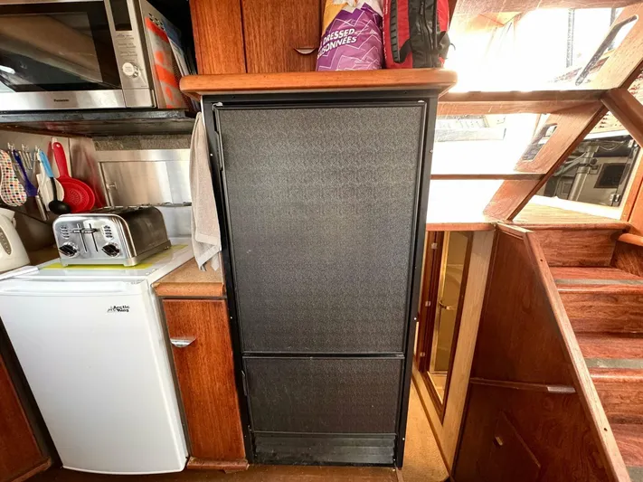  Yacht Photos Pics 1988 Bayliner 4550 Pilothouse kitchen with appliances and wooden cabinetry.