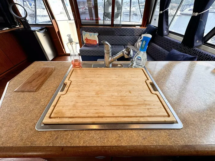 Yacht Photos Pics 1988 Bayliner 4550 Pilothouse kitchen with sink, cutting board, and cleaning supplies.