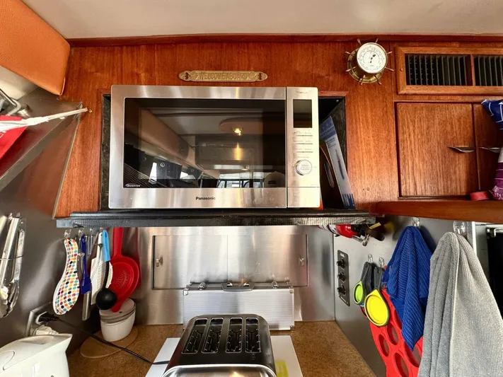  Yacht Photos Pics 1988 Bayliner 4550 Pilothouse kitchen with microwave, toaster, and wooden cabinetry.