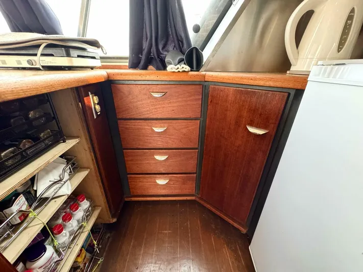  Yacht Photos Pics 1988 Bayliner 4550 Pilothouse interior with wooden cabinets and storage shelves.