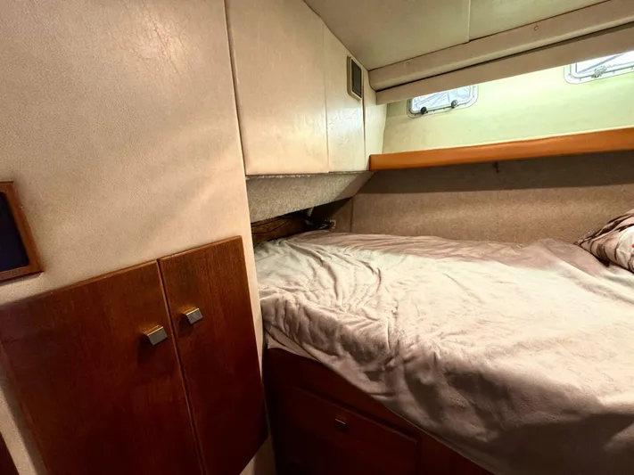  Yacht Photos Pics 1988 Bayliner 4550 Pilothouse cabin interior with bed, wooden cabinets, and small windows.
