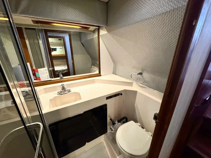  Yacht Photos Pics 1988 Bayliner 4550 Pilothouse bathroom with sink, toilet, and mirror.