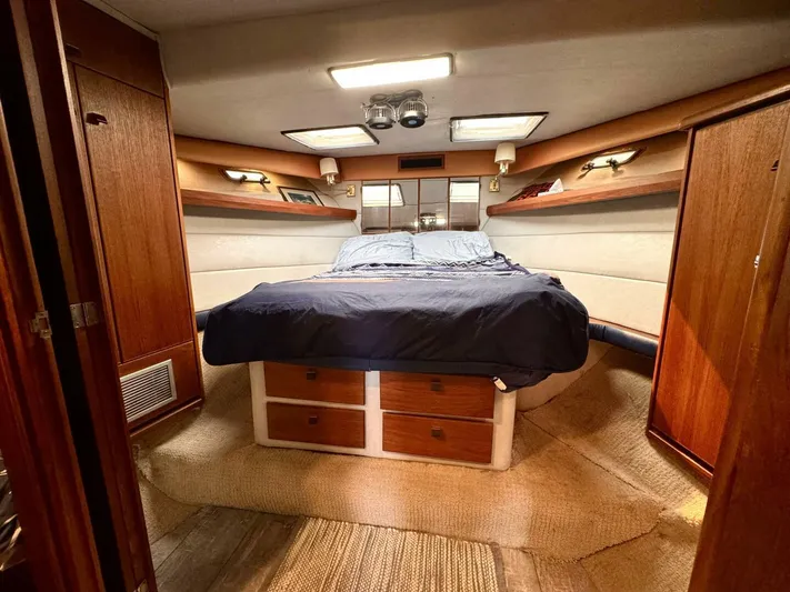  Yacht Photos Pics Luxurious 1988 Bayliner 4550 Pilothouse cabin with cozy bed and wooden storage.