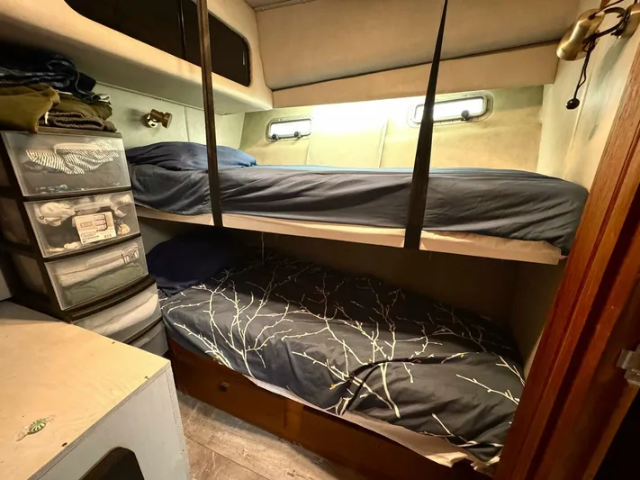  Yacht Photos Pics Bunk beds in 1988 Bayliner 4550 Pilothouse cabin with storage drawers and cozy bedding.