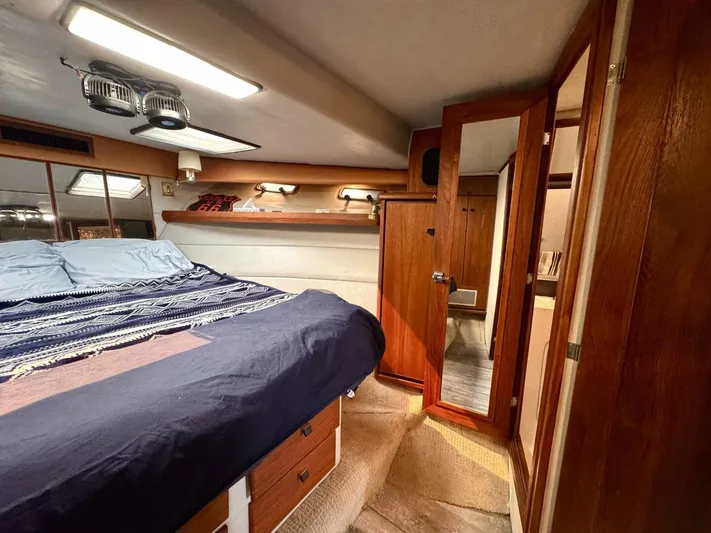  Yacht Photos Pics 1988 Bayliner 4550 Pilothouse cabin interior with bed, wood paneling, and storage.