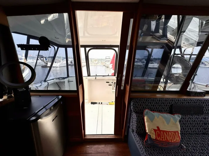  Yacht Photos Pics Interior view of 1988 Bayliner 4550 Pilothouse with marina backdrop and Canada-themed decor.
