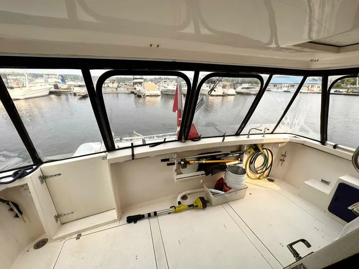  Yacht Photos Pics 1988 Bayliner 4550/4558 Pilothouse interior with marina view, featuring spacious cockpit and storage.