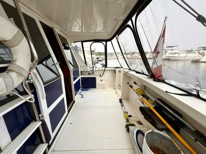  Yacht Photos Pics 1988 Bayliner 4550/4558 Pilothouse boat interior with fishing gear and marina view.