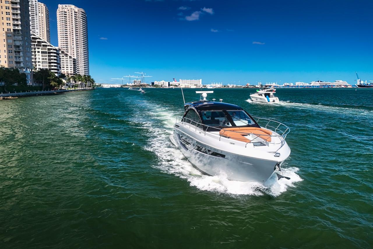 2024 Cruisers Yachts 50 Cantius cruising in a vibrant city waterfront.