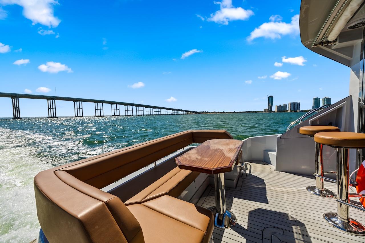 2024 Cruisers Yachts 50 Cantius on water, featuring luxurious seating and scenic city skyline.