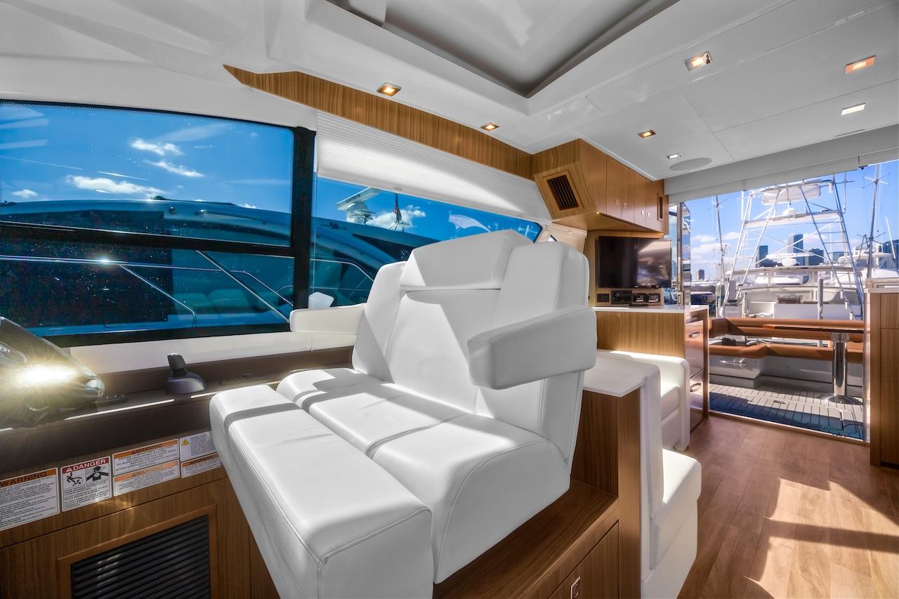 Luxurious interior of 2024 Cruisers Yachts 50 Cantius with white seating and wood accents.