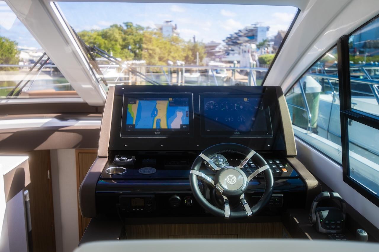 2024 Cruisers Yachts 50 Cantius helm with modern navigation displays and steering wheel.