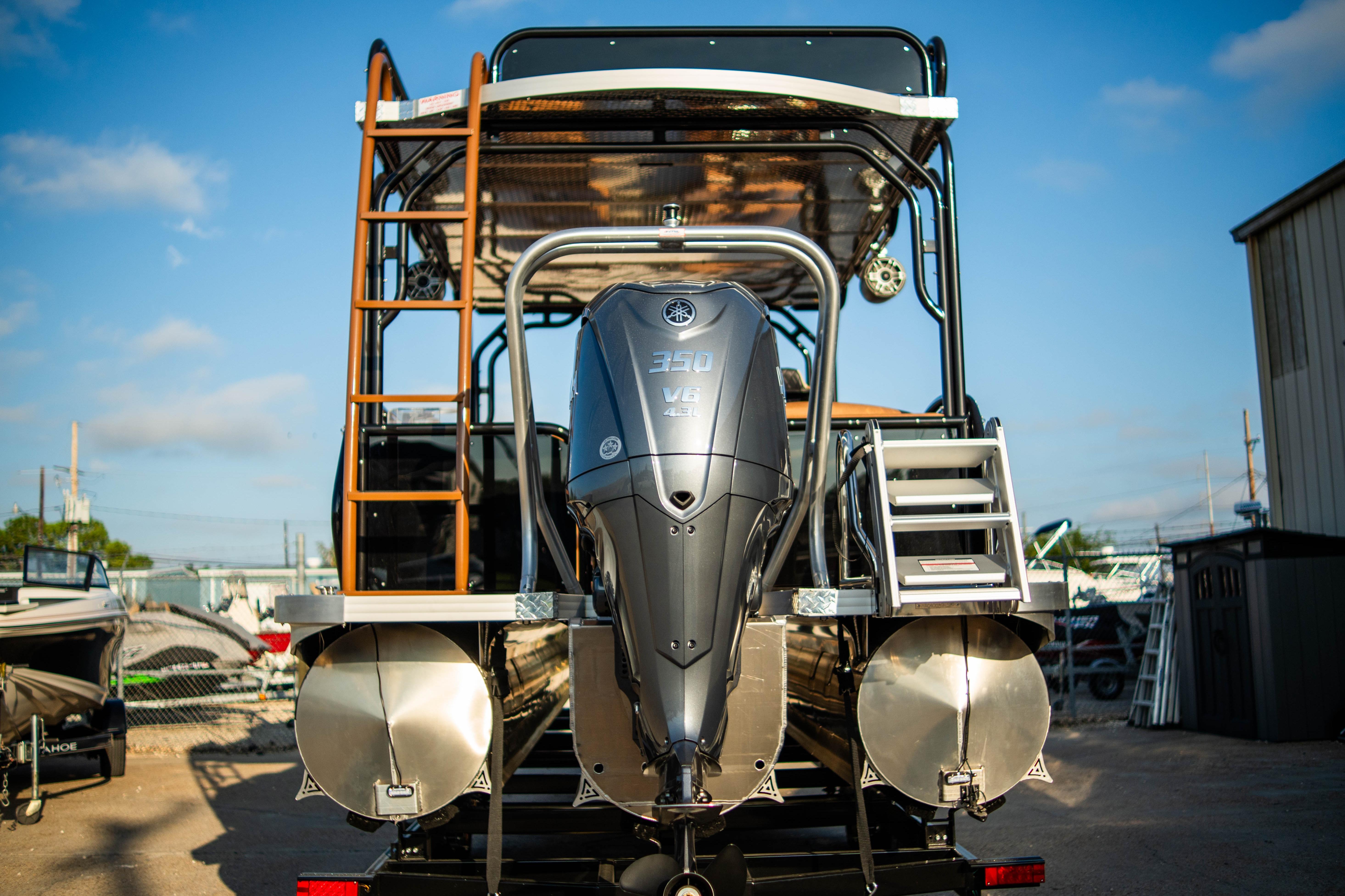 Aloha Paradise 300 Sundeck 2026 with powerful outboard motor, rear view.