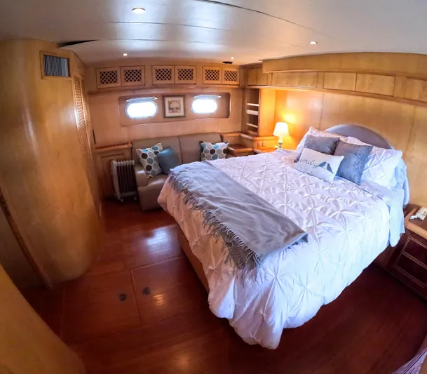 Antiquity Yacht Photos Pics Luxurious bedroom on a 1998 TransWorld Cruiser yacht with cozy decor and wooden finishes.