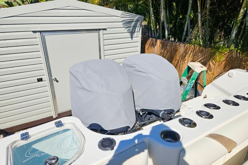 Buddy Yacht Photos Pics 2013 Sailfish 290 CC boat with covered engines, near a shed and ladder.