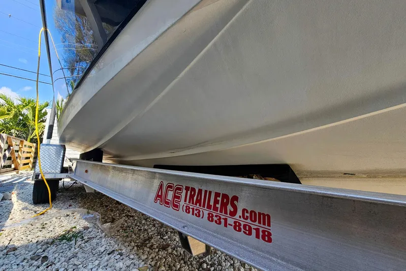 Buddy Yacht Photos Pics 2013 Sailfish 290 CC boat on Ace Trailers, parked on gravel.