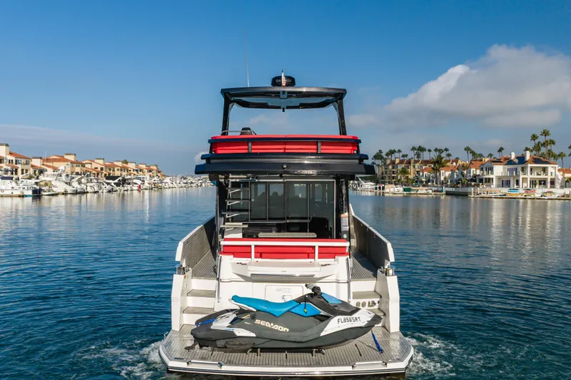 Saigon Yacht Photos Pics 2023 OKEAN 52 Fly yacht with jet ski, cruising in a scenic marina.