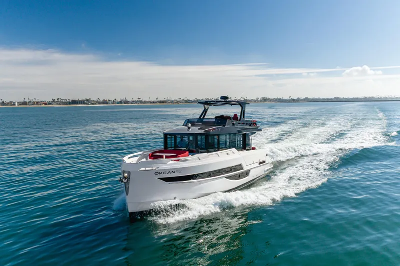 Saigon Yacht Photos Pics 2023 OKEAN 52 Fly yacht cruising on open water under clear skies.