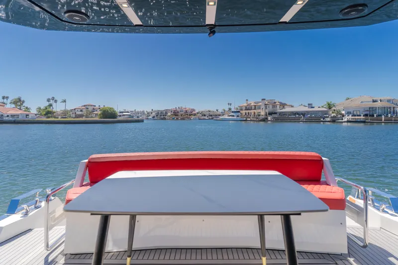 Saigon Yacht Photos Pics 2023 OKEAN 52 Fly yacht with red seating, table, and waterfront view.