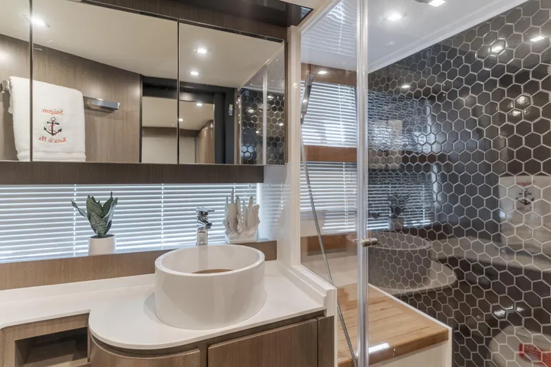 Saigon Yacht Photos Pics Luxurious bathroom in 2023 OKEAN 52 Fly yacht with modern fixtures and hexagonal tile design.