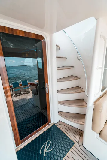 Relentless Yacht Photos Pics 2006 Bertram Sportfish yacht interior with spiral staircase and ocean view.