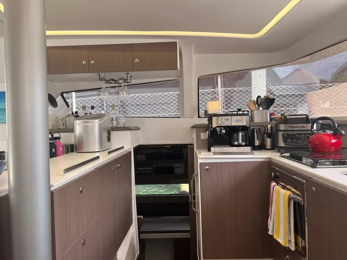 Encore Yacht Photos Pics Modern kitchen interior on a 2020 Bali 4.1 yacht with appliances and wooden cabinets.