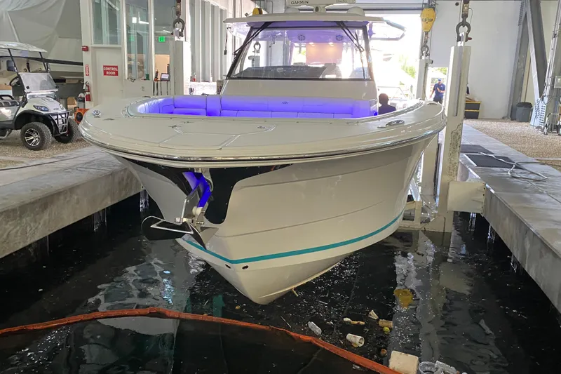  Yacht Photos Pics 2021 Regal 38 SAV boat in a marina, featuring sleek design and blue interior lighting.