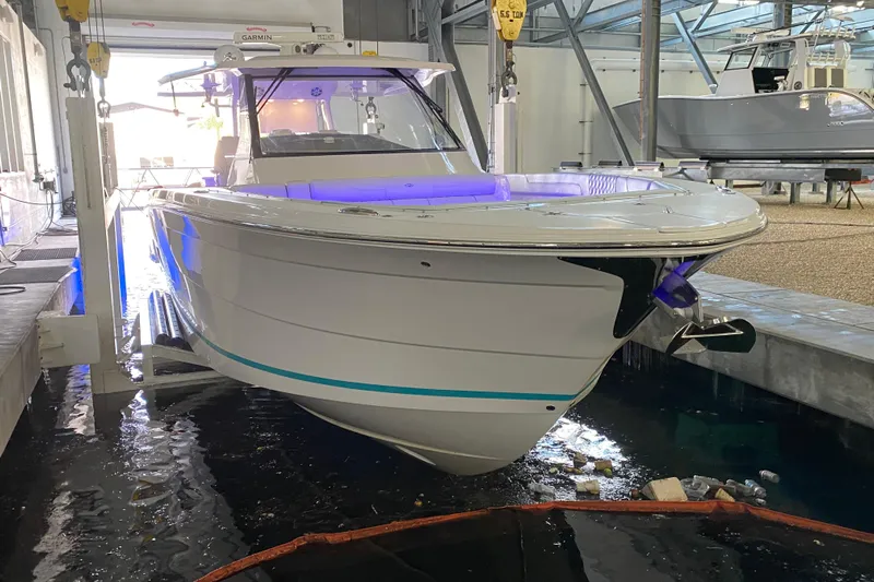  Yacht Photos Pics 2021 Regal 38 SAV boat in a marina, illuminated with blue lights.