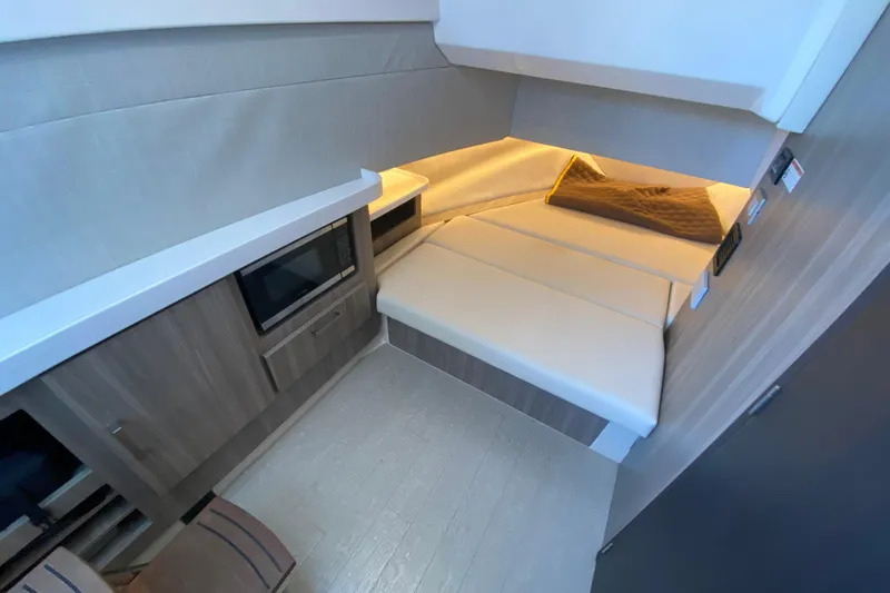  Yacht Photos Pics 2021 Regal 38 SAV interior cabin with modern design, featuring a cozy bed and microwave.
