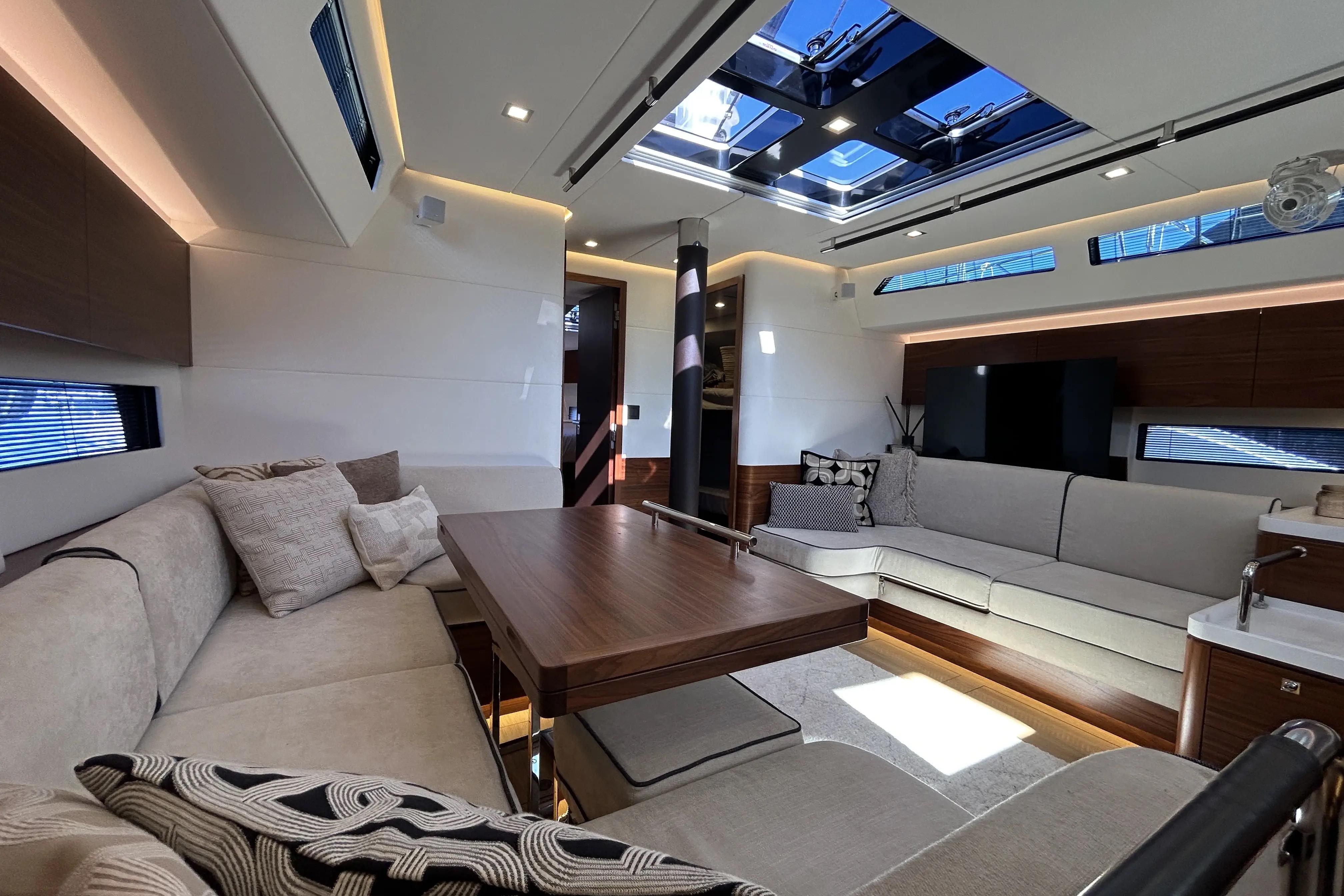 Luxurious interior of 2022 Amel 50 yacht with modern seating and skylight.