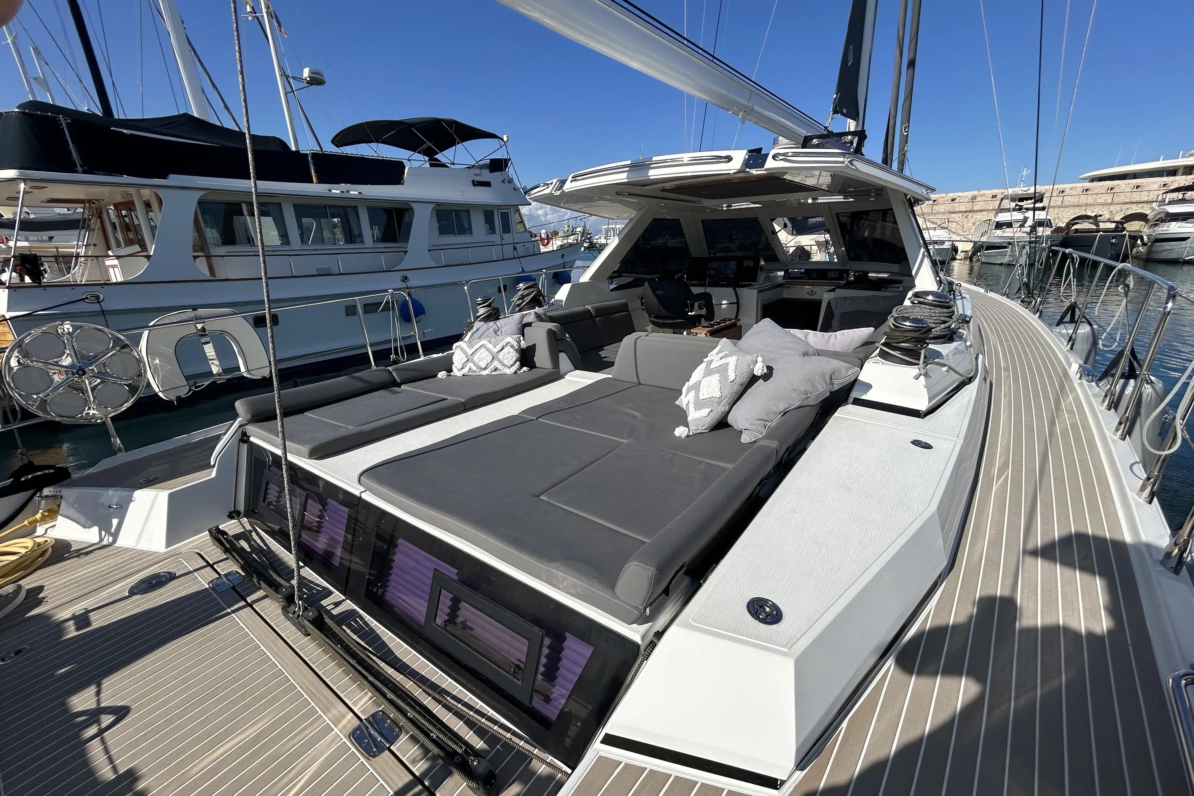 Luxurious 2022 Amel 50 yacht with spacious deck and modern seating in marina.