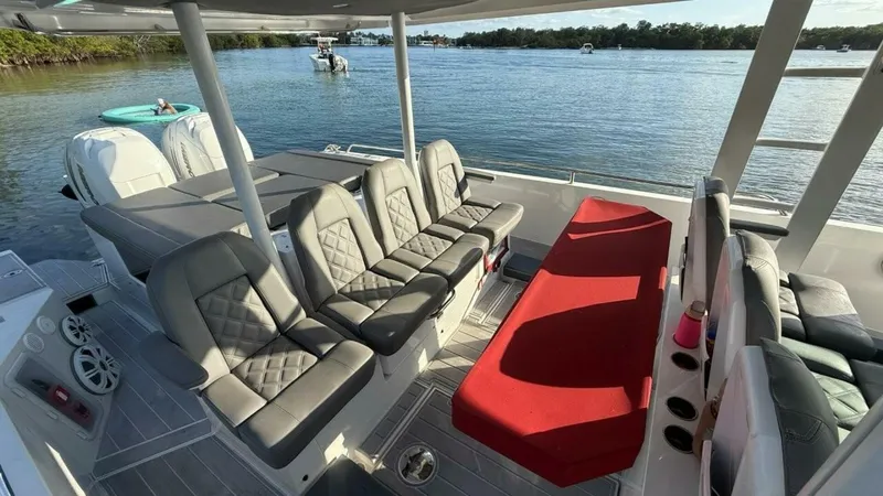 No Name Yacht Photos Pics 2019 Axopar 37 Sun Top boat interior with gray seating and red sunbed on the water.
