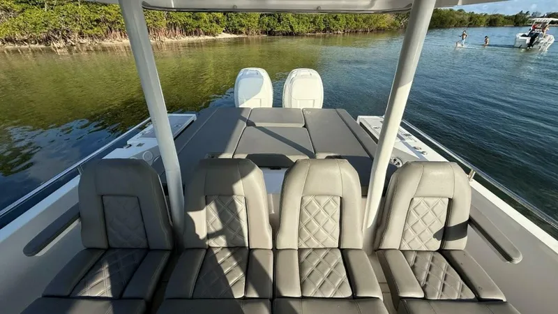 No Name Yacht Photos Pics 2019 Axopar 37 Sun Top boat with luxurious seating, docked near a serene shoreline.