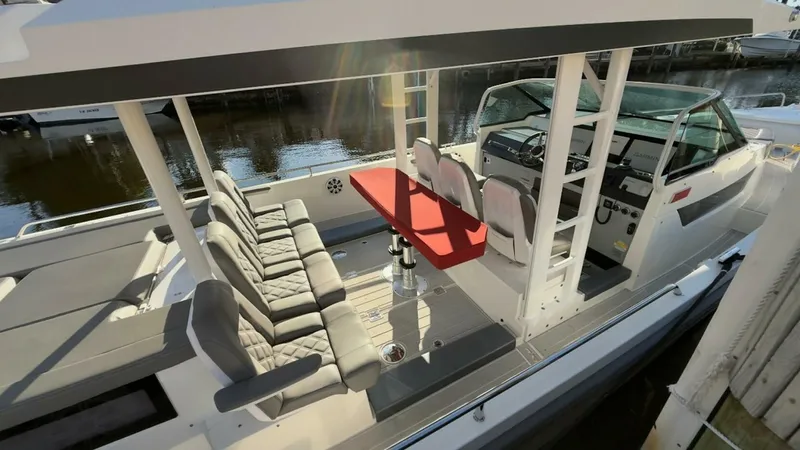 No Name Yacht Photos Pics 2019 Axopar 37 Sun Top boat with spacious seating and modern helm, docked by the water.