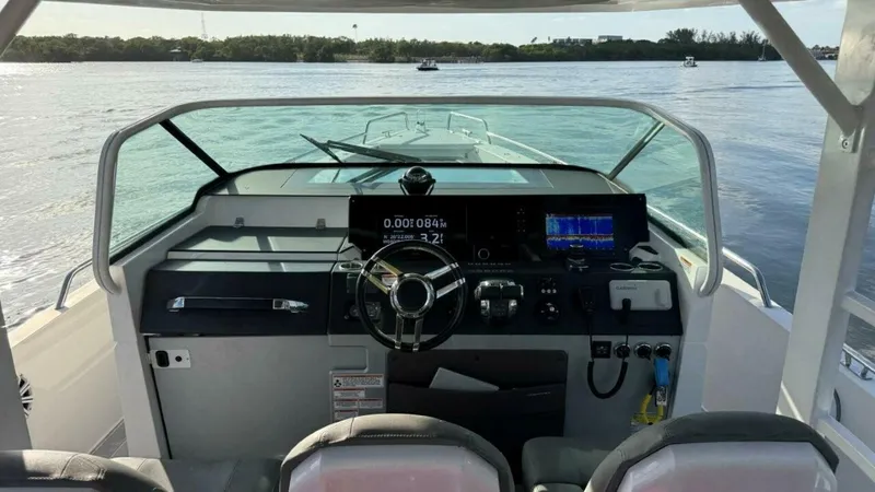 No Name Yacht Photos Pics 2019 Axopar 37 Sun Top boat dashboard with steering wheel and navigation screens.