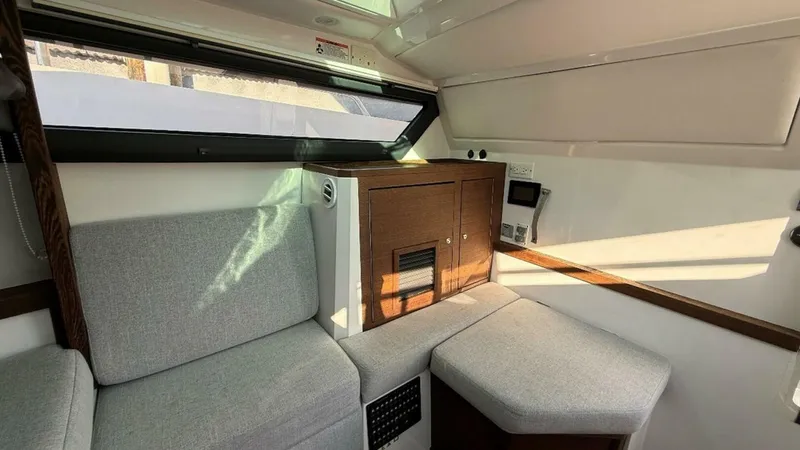No Name Yacht Photos Pics 2019 Axopar 37 Sun Top interior with gray seating and wooden cabinetry.
