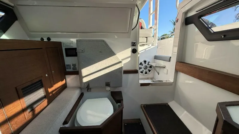 No Name Yacht Photos Pics Interior of 2019 Axopar 37 Sun Top boat, featuring compact bathroom and wooden accents.