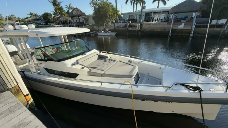 No Name Yacht Photos Pics 2019 Axopar 37 Sun Top boat docked by a waterfront with palm trees.