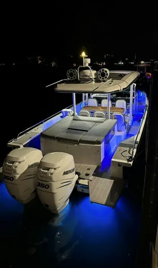 No Name Yacht Photos Pics 2019 Axopar 37 Sun Top boat with illuminated deck and twin Mercury engines at night.