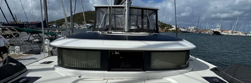 Samcat Yacht Photos Pics 2020 Lagoon 46 catamaran docked at a marina with scenic waterfront views.