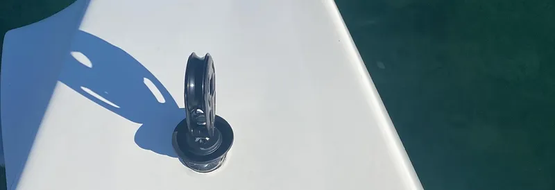 Samcat Yacht Photos Pics Close-up of a 2020 Lagoon 46 yacht deck detail with pulley against blue water.
