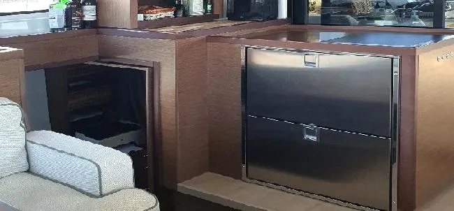 Samcat Yacht Photos Pics Modern interior of 2020 Lagoon 46 yacht with stainless steel appliances and wooden cabinetry.