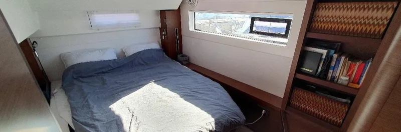Samcat Yacht Photos Pics Cozy bedroom in 2020 Lagoon 46 yacht with window view and bookshelf.