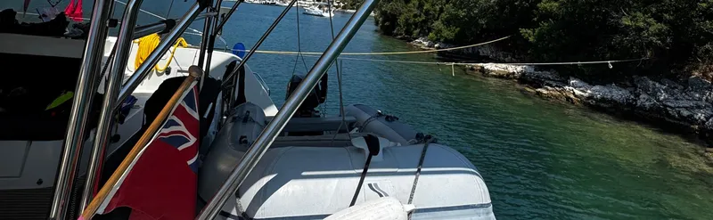 Samcat Yacht Photos Pics 2020 Lagoon 46 catamaran docked in a serene, tree-lined coastal area.