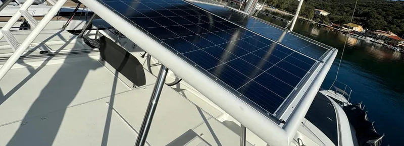 Samcat Yacht Photos Pics Solar panel on 2020 Lagoon 46 catamaran, docked by a serene waterfront.