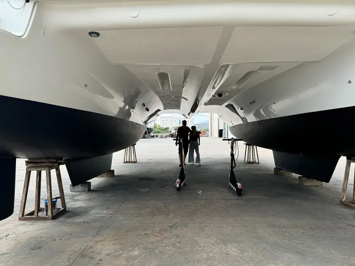 Samcat Yacht Photos Pics Underneath view of a 2020 Lagoon 46 catamaran in a shipyard.