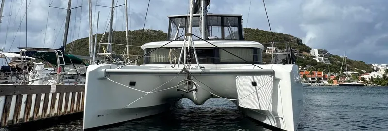 Samcat Yacht Photos Pics 2020 Lagoon 46 catamaran docked in a scenic marina with hills in the background.